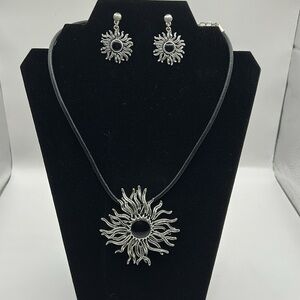 Silvertone sunburst necklace and earring set.  Leather strap.